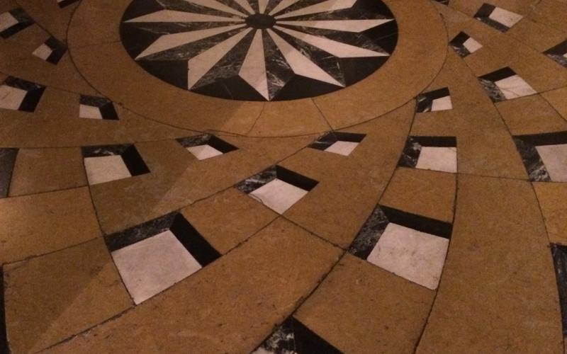 Pavimento in marmo con decoro centrale a rosone e fasce che si dipartono dal centro